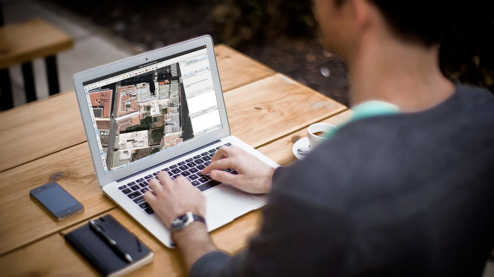 Person working with aerial map imagery on a laptop